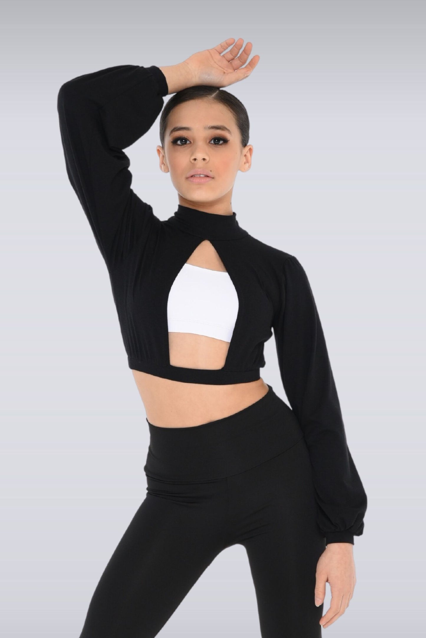 Girl wearing a black bishop sleeve, crop top with front split cutout,  tie neck blouse.